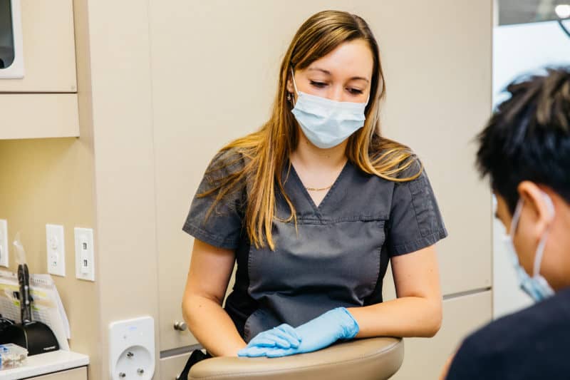 a polo park dental team member assisting a dentist